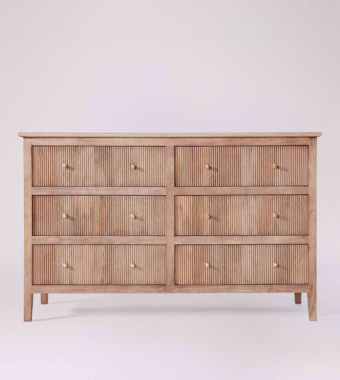 Wooden dresser with four drawers on a white background