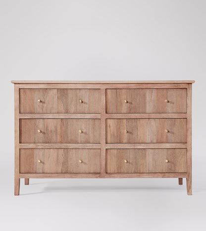 Wooden dresser with four drawers on a white background