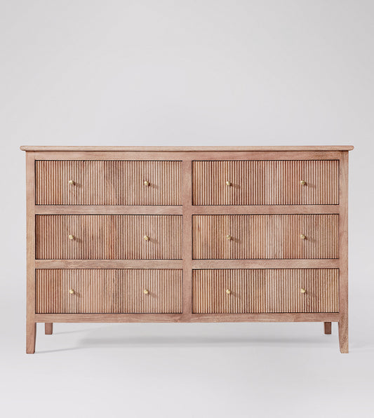 Wooden dresser with four drawers on a white background