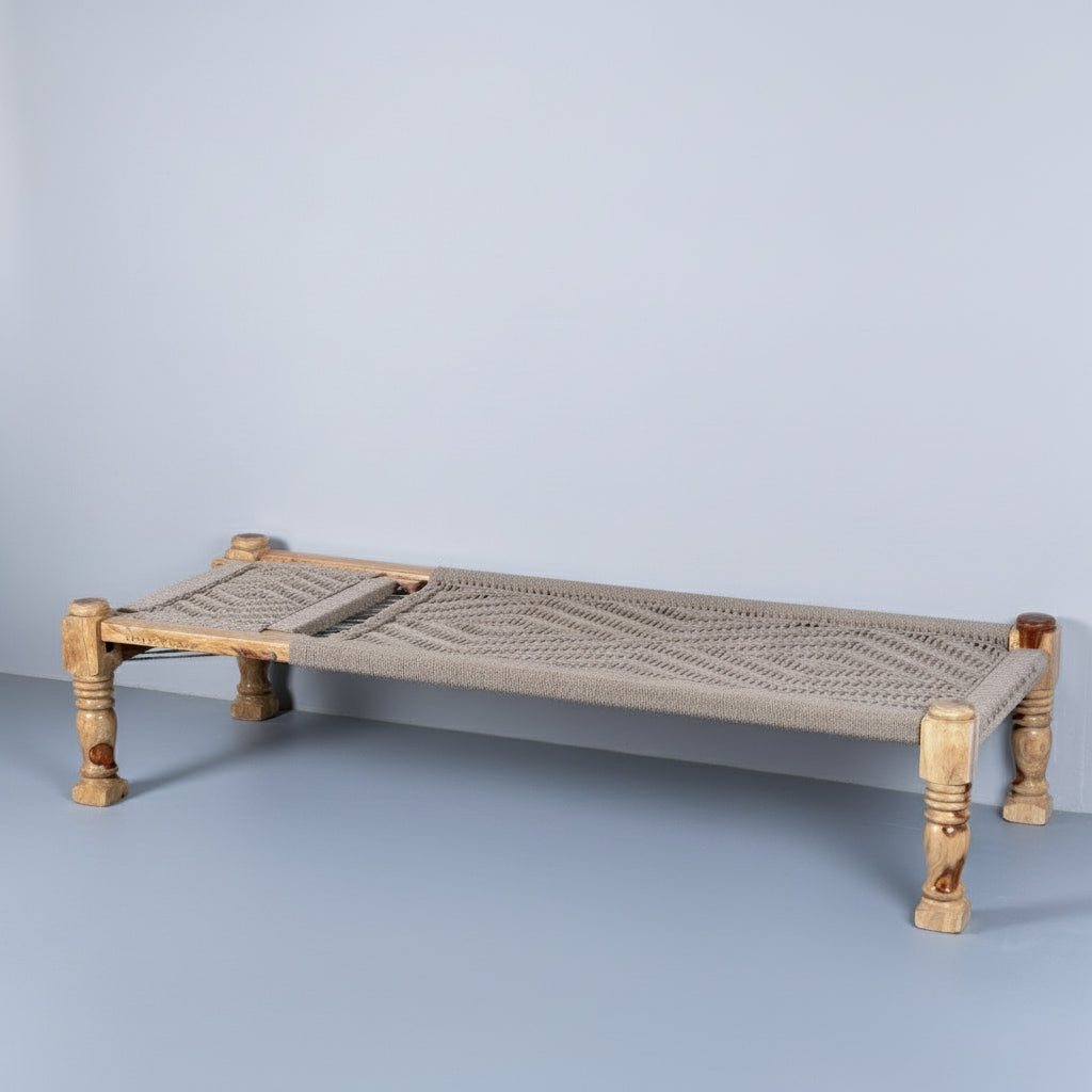 Woven daybed with colorful cushions on a plain background