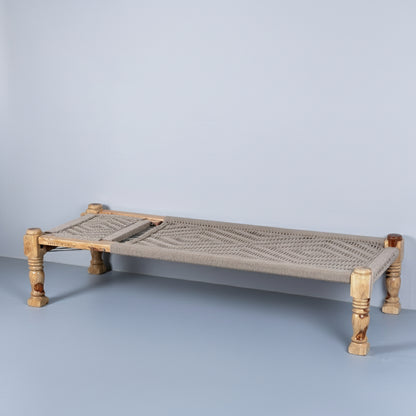 Woven daybed with colorful cushions on a plain background